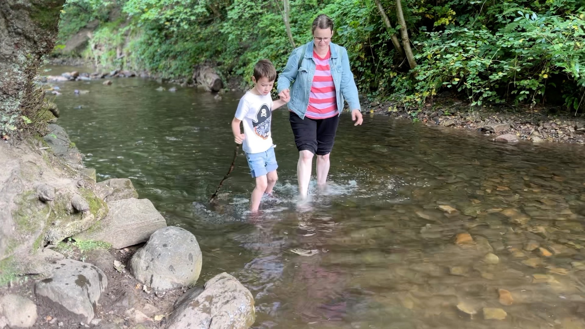 A mother and son doing a river walk at the Hermitage of Braid in Edinburgh